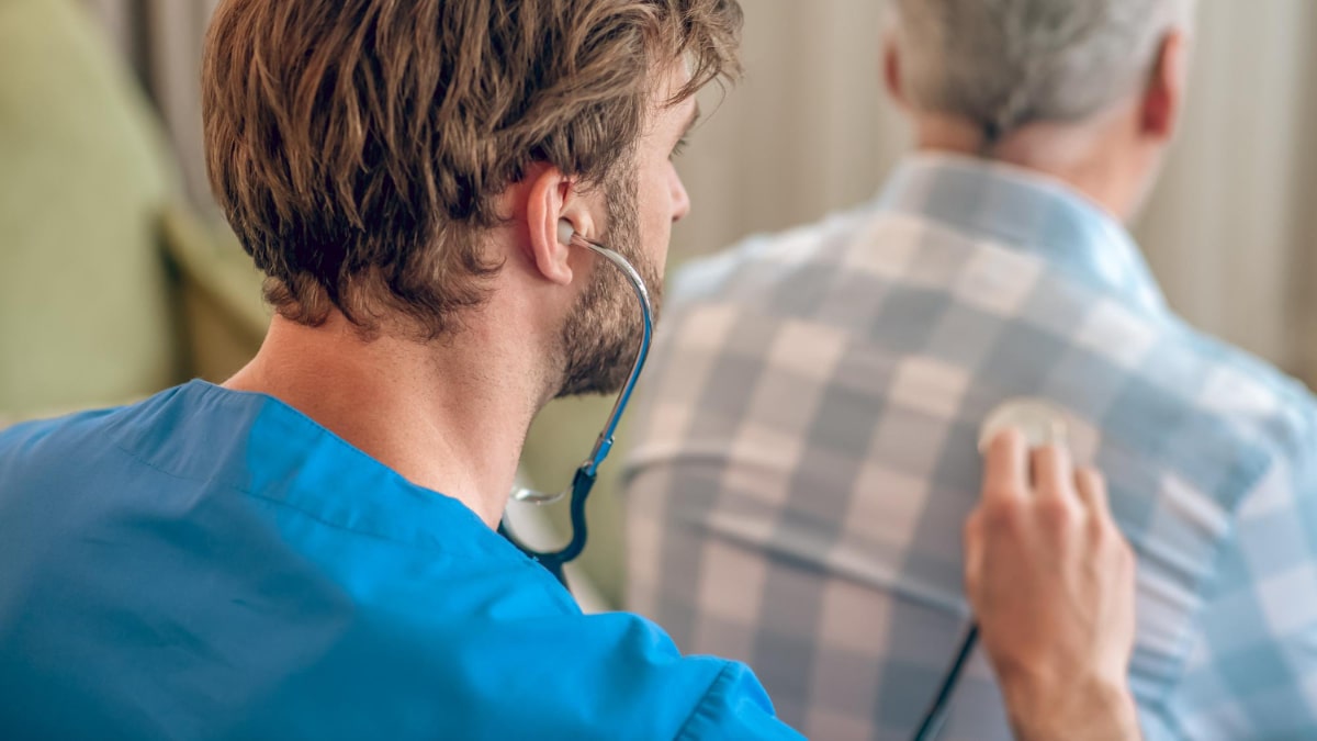 Un médico ausculta a un paciente para cuidar sus pulmones