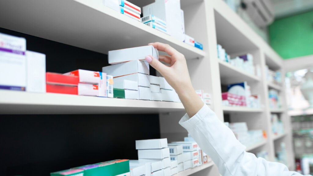 Una farmaceutica recoge una caja de ibuprofeno con arginina