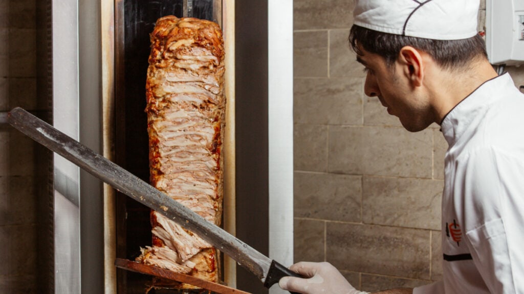 Un cocinero cortando un kebab