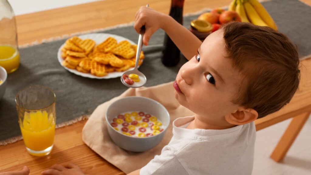 Un niño merendando cereales y zumo