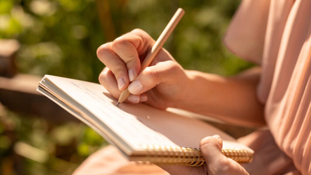 Una mujer escribe a mano en un cuaderno