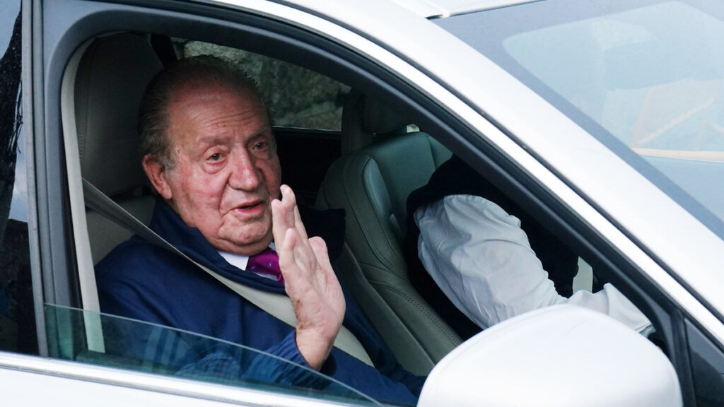 Juan Carlos I saluda desde un vehículo a su salida de la casa de Sanxenxo