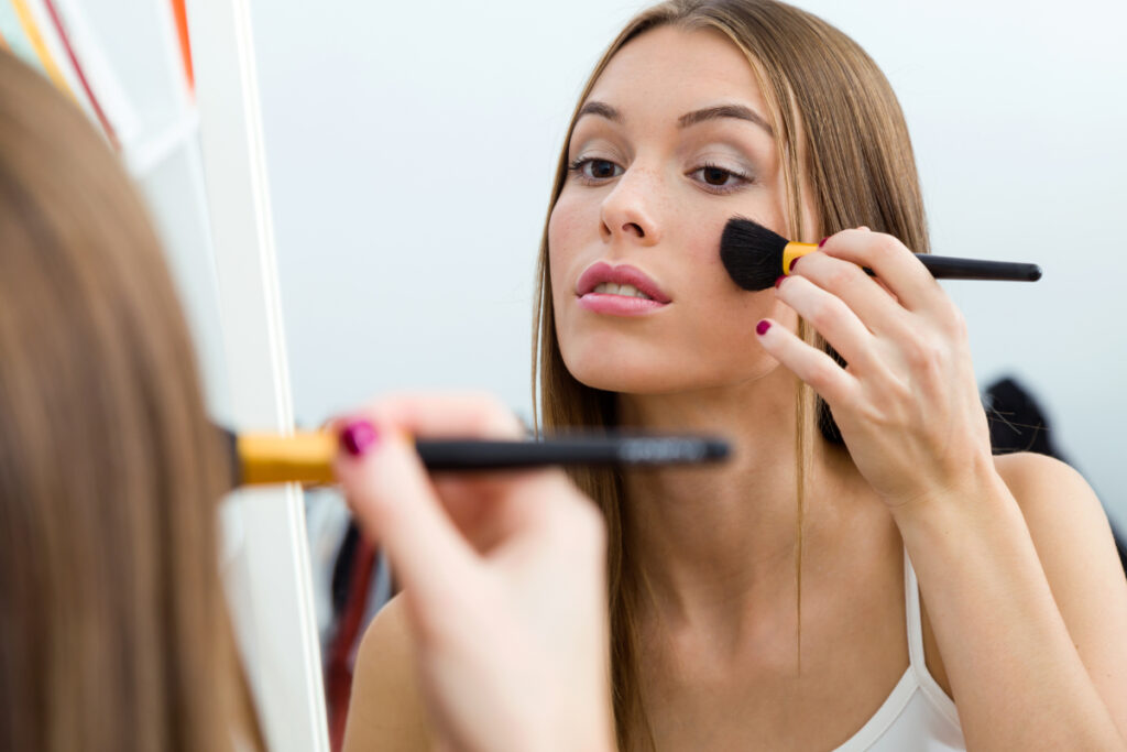 Mujer aplicando colorete en los pómulos. (Fuente: Freepik/nensuria)