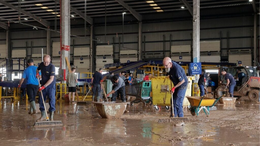 Personas limpiando el fango tras la inundación.