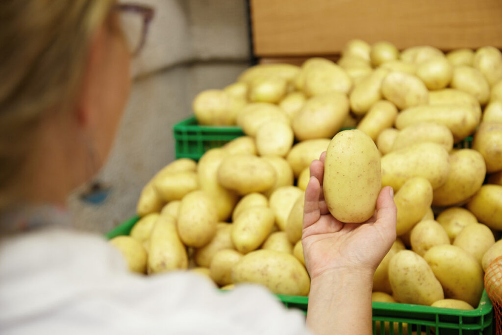 Mujer comprando patatas. (Fuente: Freepik/wayhomestudio)