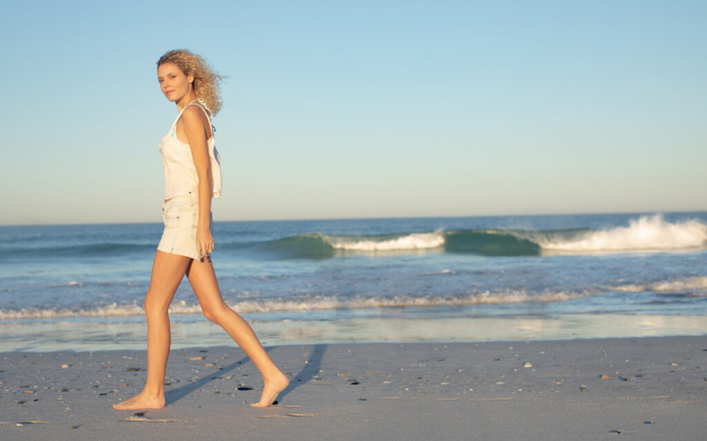 Pasear por la playa es un buen ejercicio para las piernas. (Fuente: Freepik/wavebreakmedia_micro)