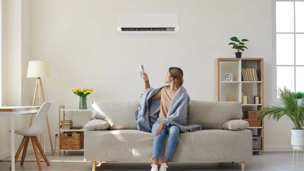 Mujer con aire acondicionado en su hogar | Canva