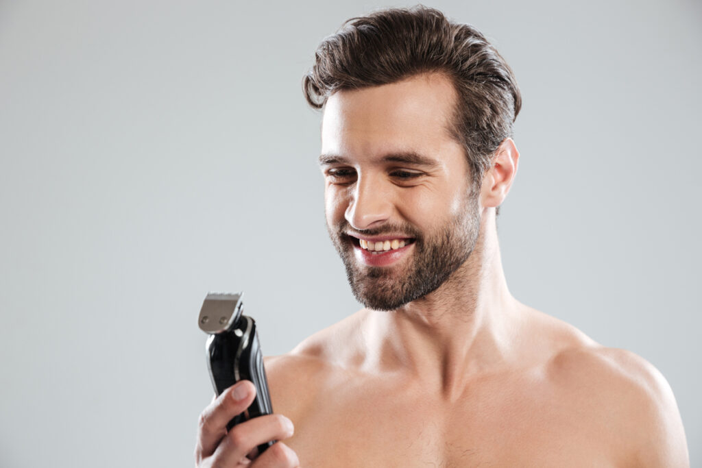 Hombre con maquinilla de afeitar. (Fuente: Freepik/drobotdean)