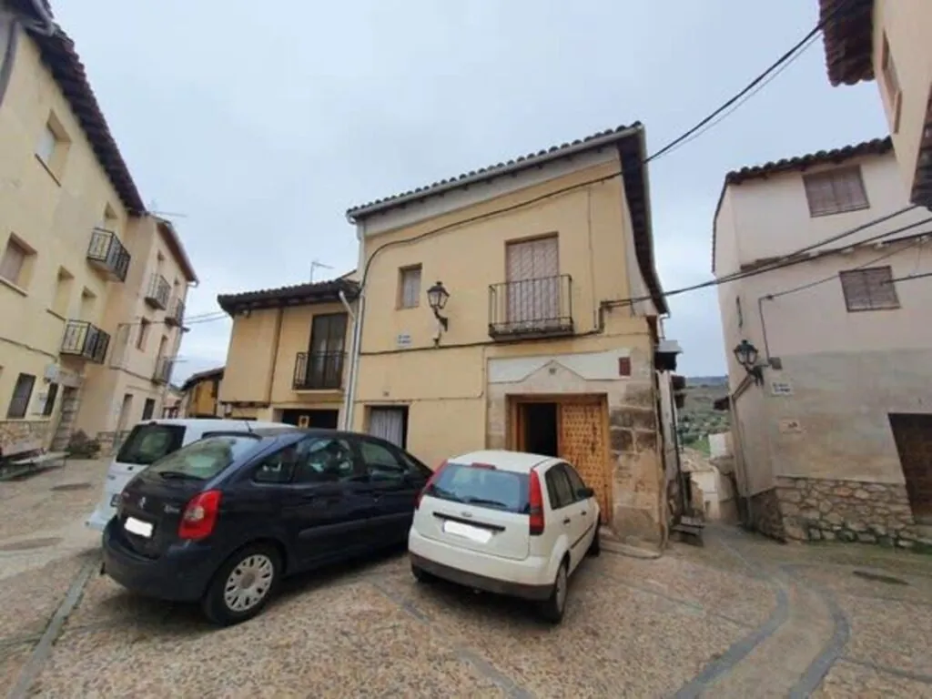 La fachada de la casa de Caixa Bank a la venta por 22.000 euros en Pastrana, Guadalajara. BuildingCenter