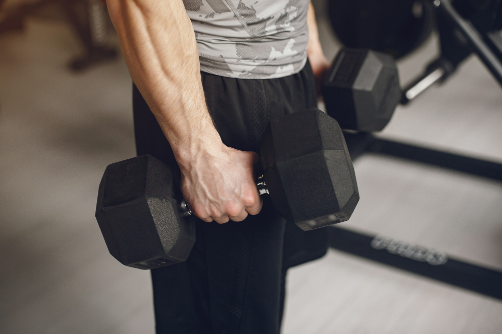 Hombre con mancuernas en el gimnasio. (Fuente: Freepik/prostooleh)