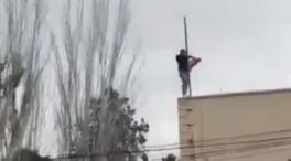 Un grupo de manifestantes retira la bandera de Irán de la embajada en Madrid