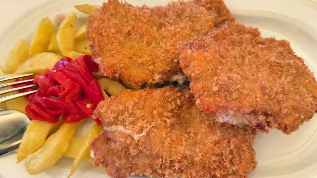 Cachopines de solomillo de cerdo con patatas fritas y pimientos en el restaurante El Llagar de Titi, Asturias.