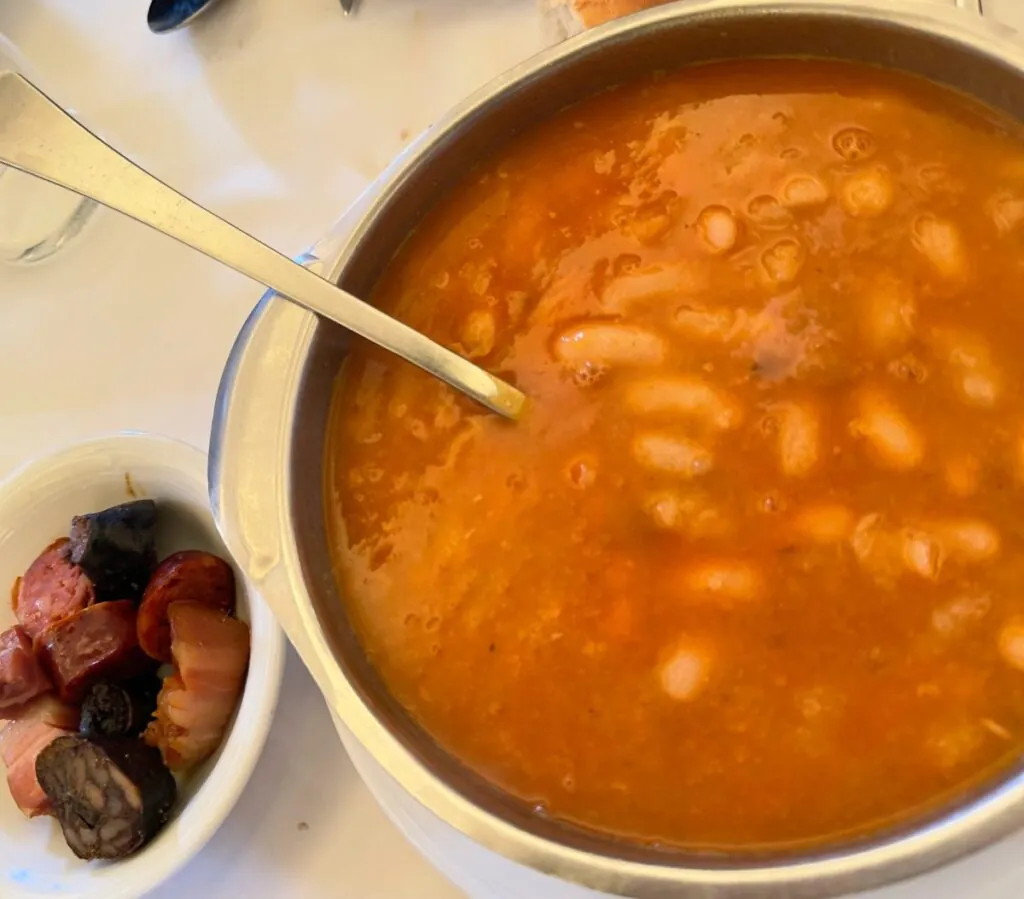 Cazuela de fabada asturiana tradicional con su compango (chorizo, morcilla, lacón) servida en el restaurante El Llagar de Titi.