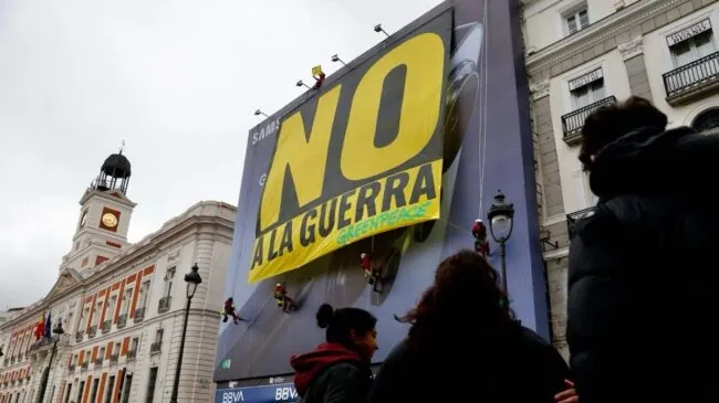 Greenpeace descuelga en la Puerta del Sol una gran pancarta con un 'No a la guerra'