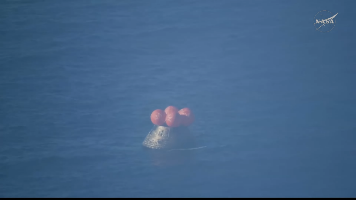 Una cápsula cónica con un grupo de flotadores rojos sobre su techo flotan en el mar