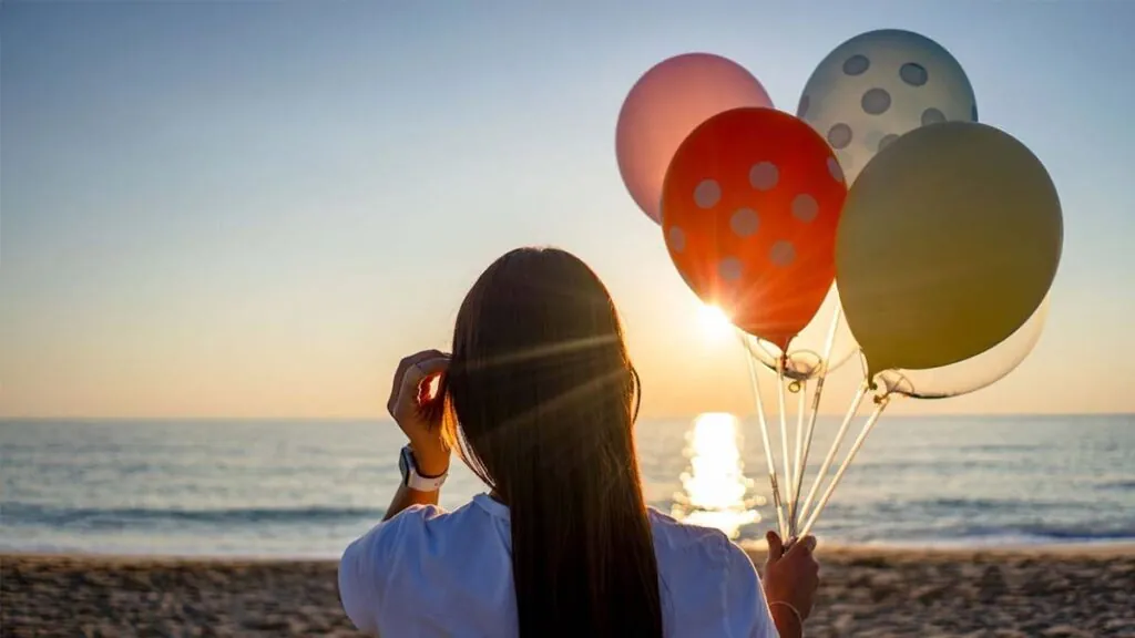 mujer-felicidad-globos-playa