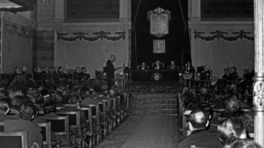 Ceremonia de celebración del 250 aniversario de la Real Academia Española (RAE) en la que el académico José María Pemán da un discurso frente a los académicos